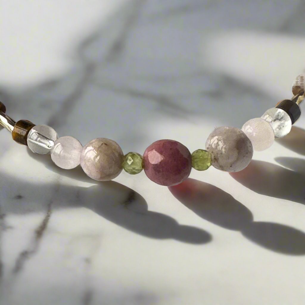 Taurus Birthstone Healing Crystal bracelet for Love and Compassion showing Rose Quartz, Peridot, Kunzite, Rhodonite, Tiger’s Eye and Clear Quartz