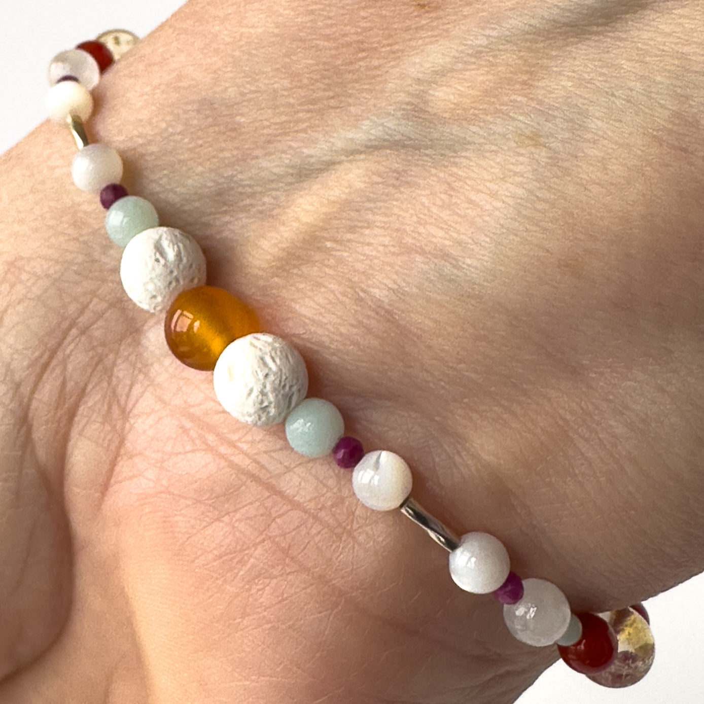 Virgo Birthstone Healing Crystal bracelet for Grief & Loss support on wrist showing Carnelian, Amazonite, Sugilite, Moonstone and Lava Stone