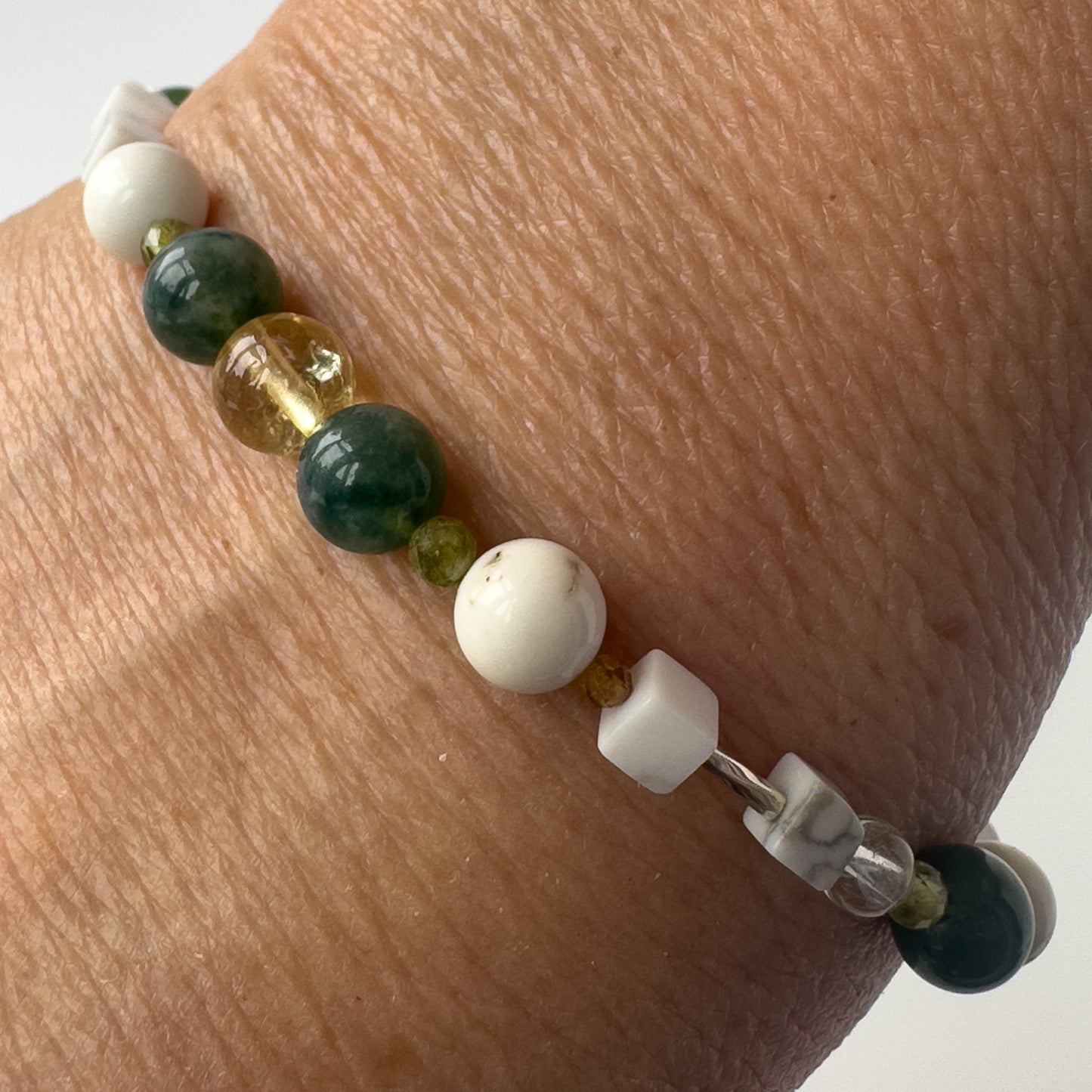 Virgo Healing Crystal bracelet for Love on wrist showing Citrine, Peridot, Moss Agate, Garnet, Howlite and Magnesite