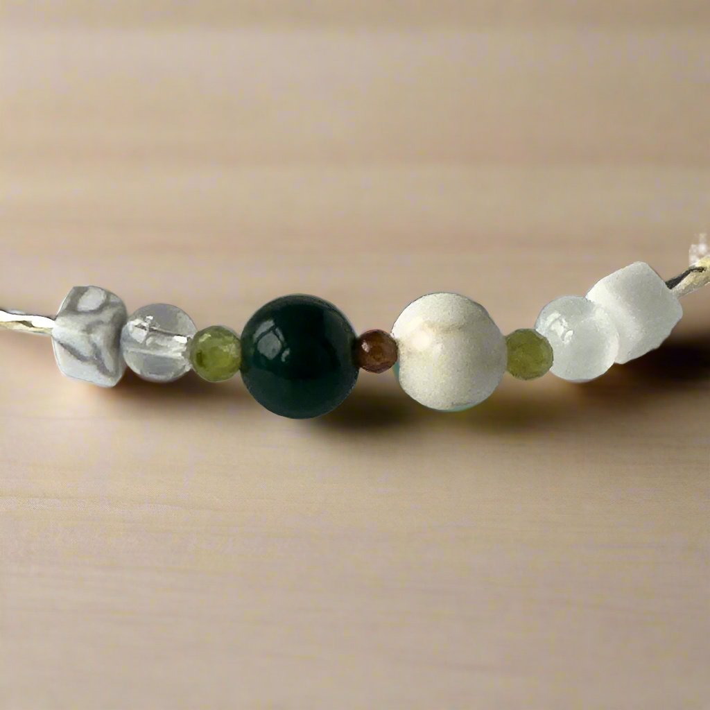 Virgo Birthstone Healing Crystal bracelet for Love and Compassion showing Peridot, Moss Agate, Garnet, Howlite, Magnesite, Selenite and Clear Quartz