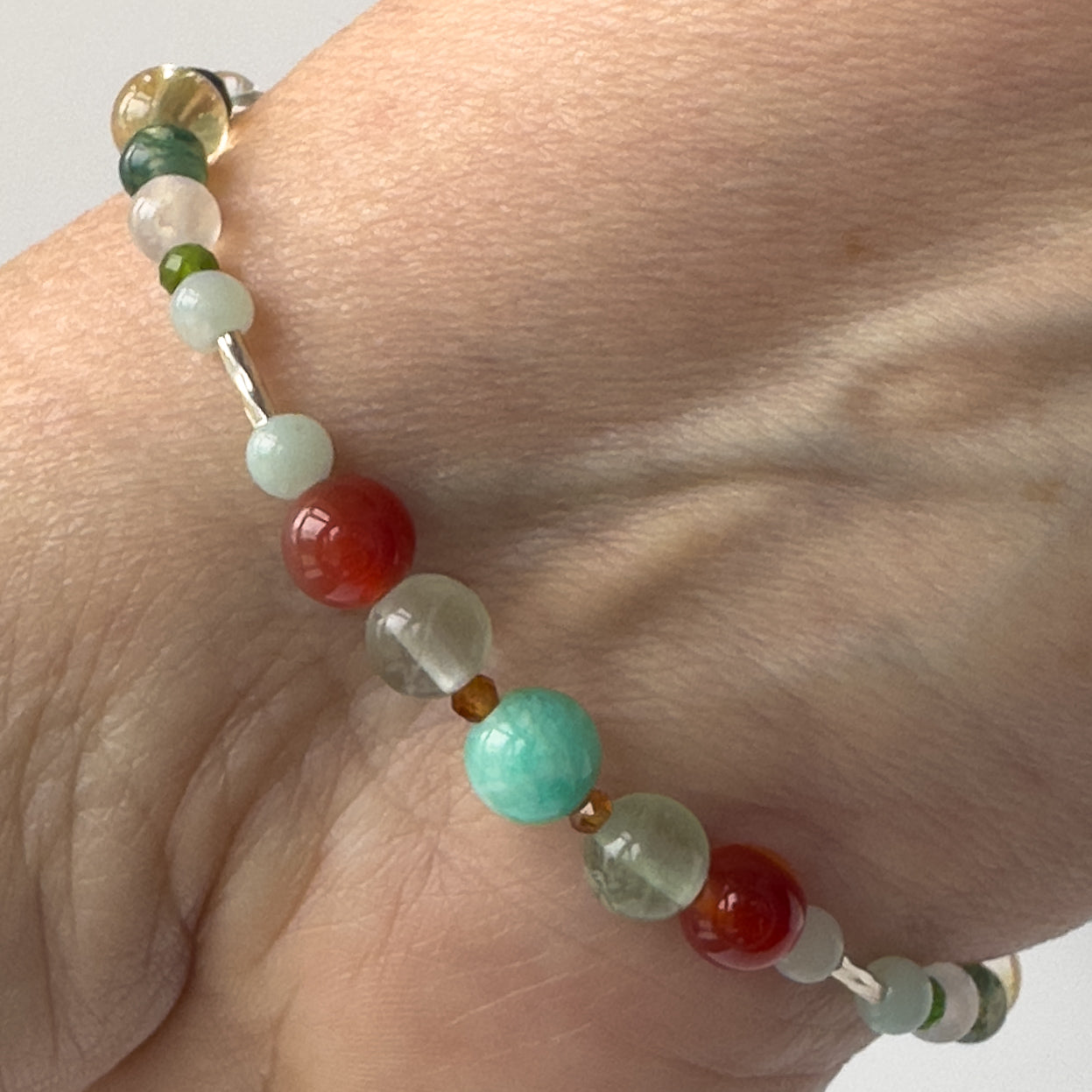 Virgo Birthstone Healing Crystal bracelet for Determination & Willpower on wrist showing Sardonyx, Rainbow Fluorite, Garnet and Amazonite